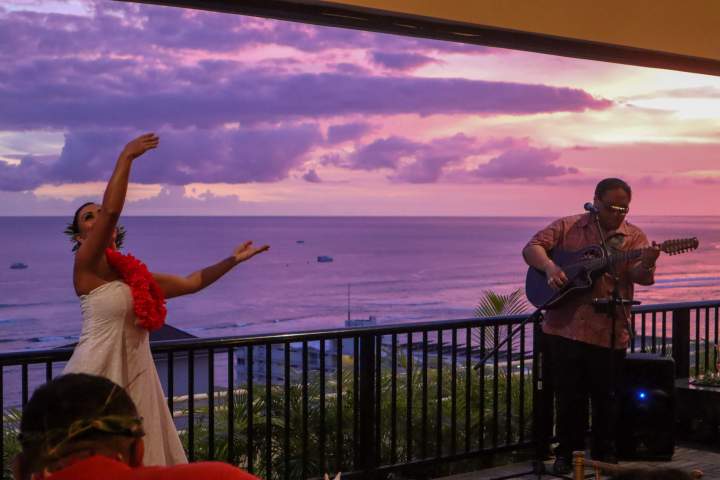 a man and a woman standing in front of a fence